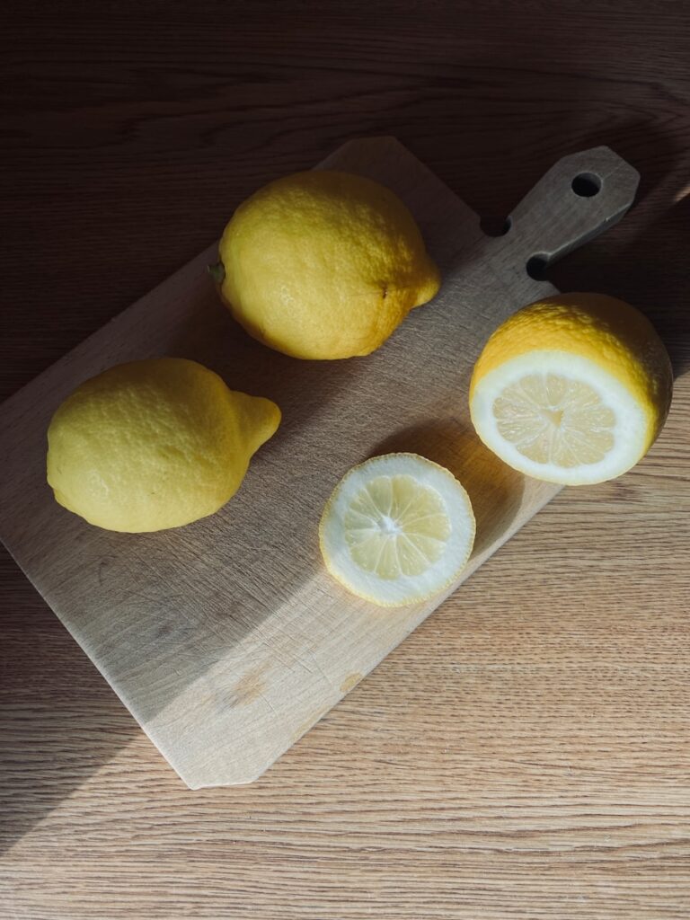 a cutting board with lemons and a knife on it