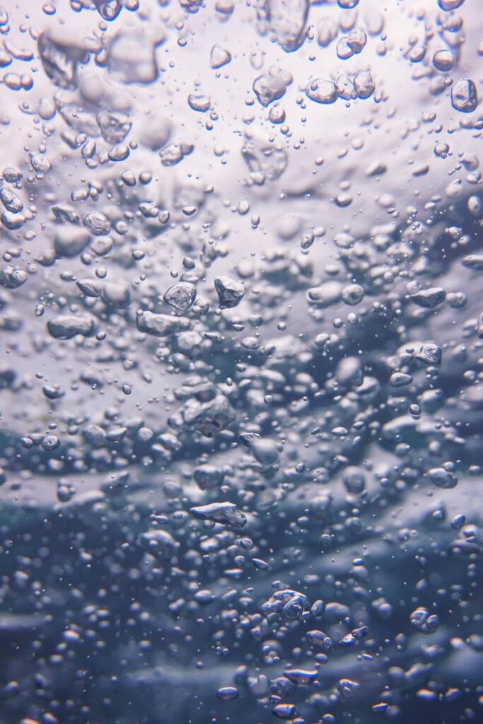 Bubbles rising through clear blue water