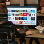 a woman sitting in front of a computer monitor