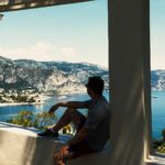 man in gray t-shirt sitting on window during daytime