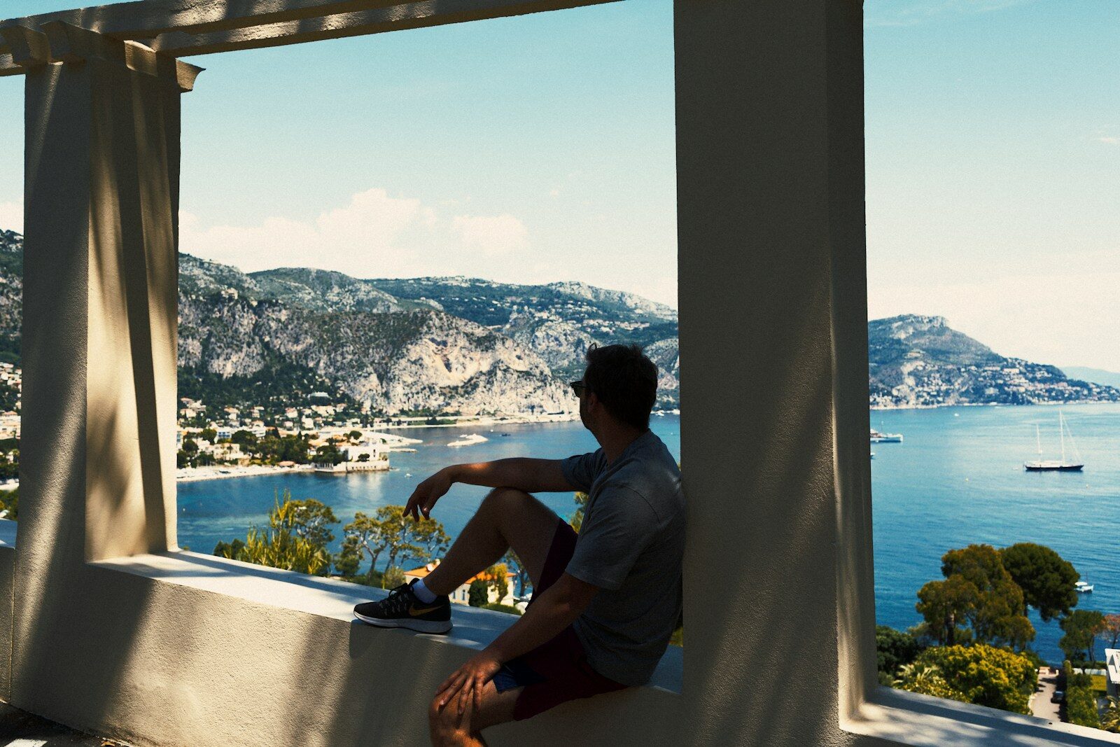 man in gray t-shirt sitting on window during daytime
