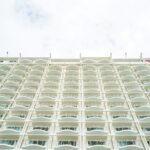 a tall white building with balconies on the sides