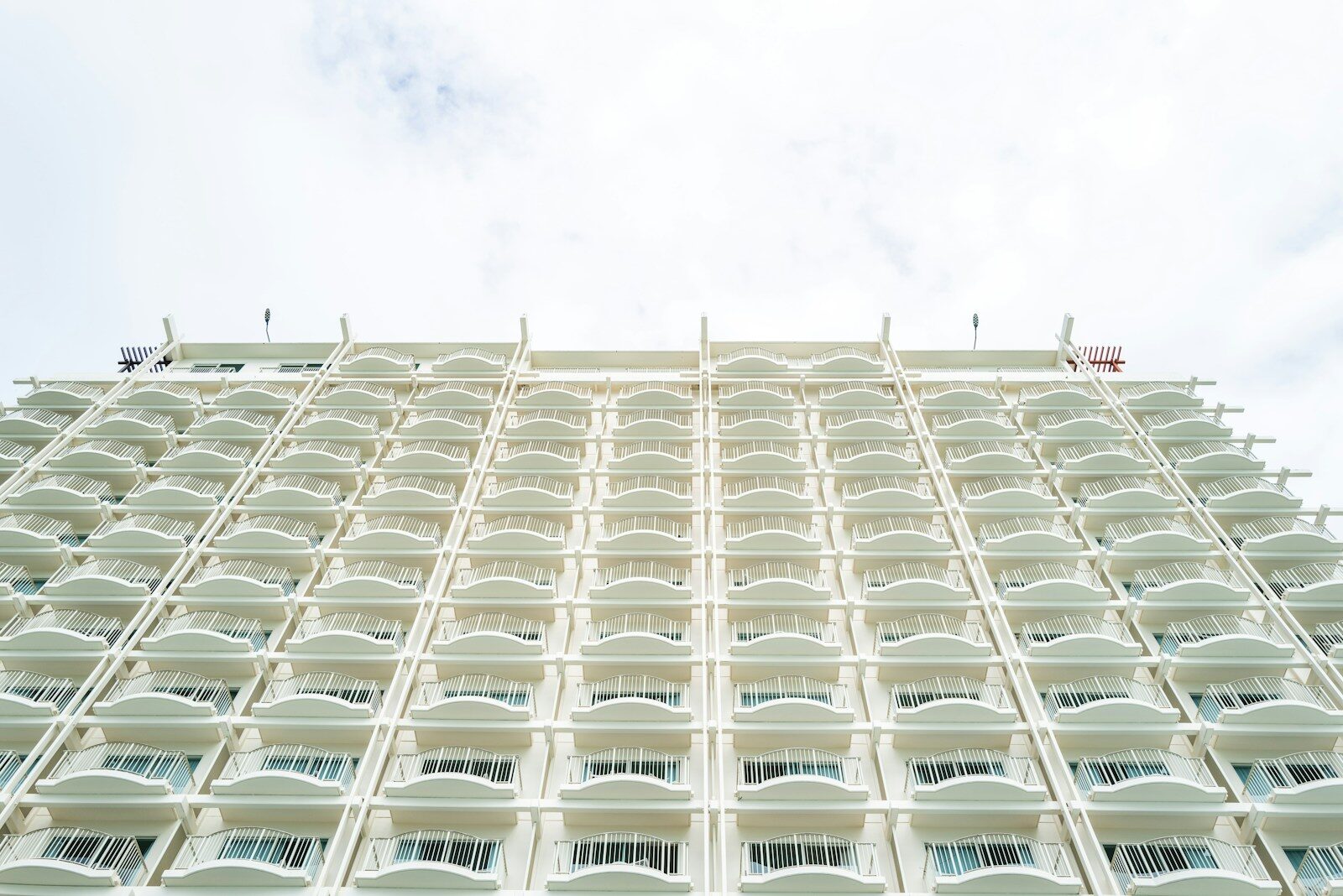 a tall white building with balconies on the sides